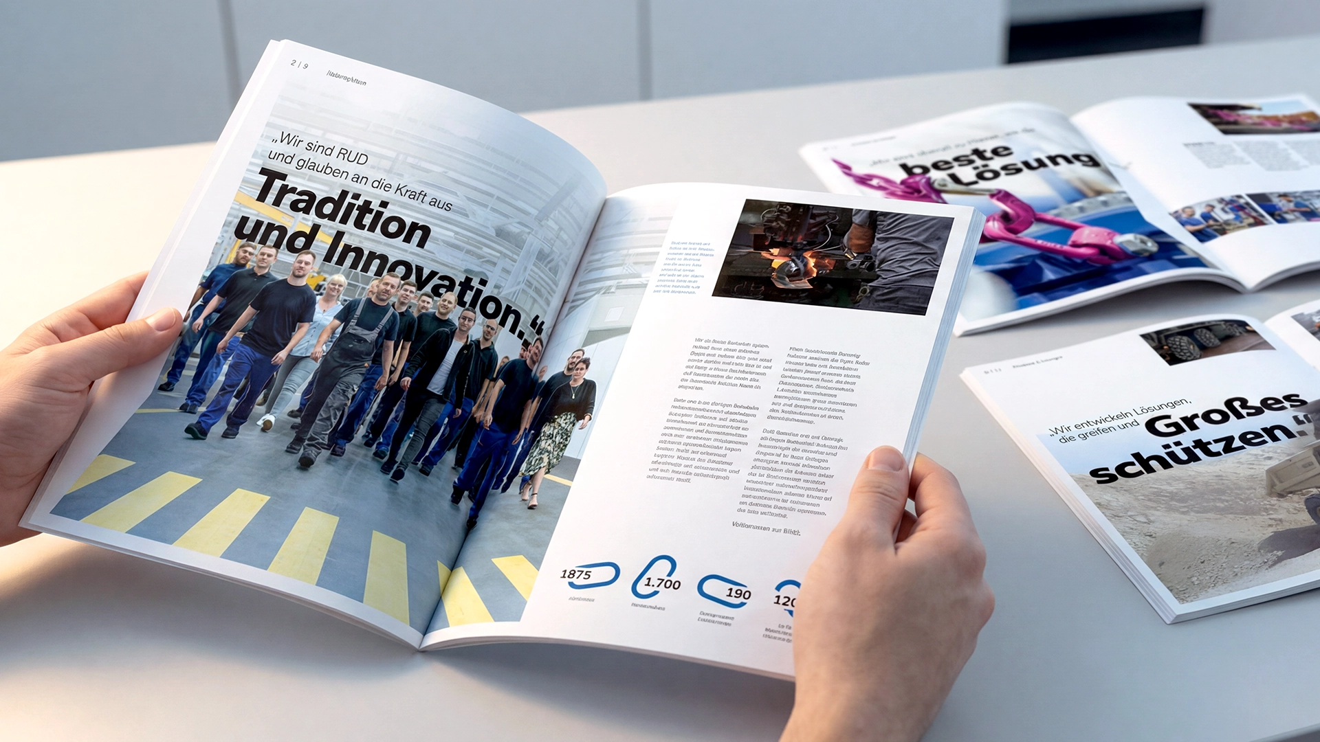 RUD Case Study – Hände halten aufgeschlagene RUD-Imagebroschüre mit Reportage-Layout, weitere Druckstücke daneben – Fotografie von LässingMüller