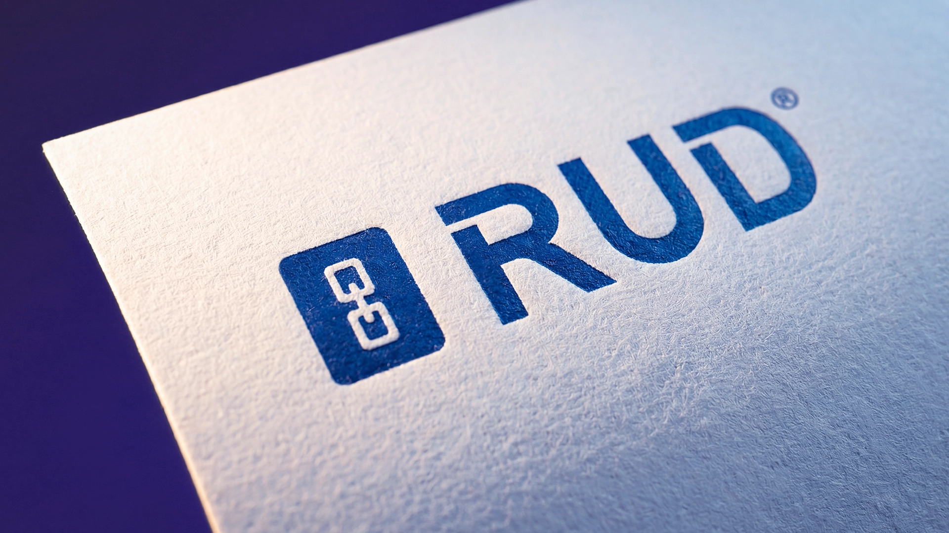 RUD Case Study – Nahaufnahme des blauen RUD-Logos auf strukturiertem Papier – Fotografie von LässingMüller