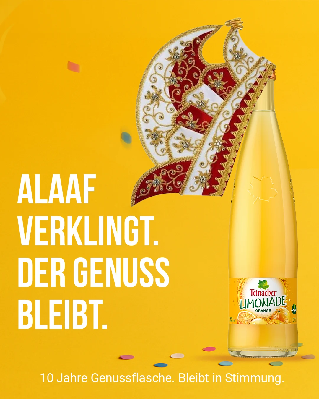 Teinacher-Kampagnenmotiv 'Alaaf verklingt – der Genuss bleibt': bestickte Karnevalsmütze auf einer Flasche Teinacher Limonade Orange, verstreutes Konfetti, vor gelbem Hintergrund