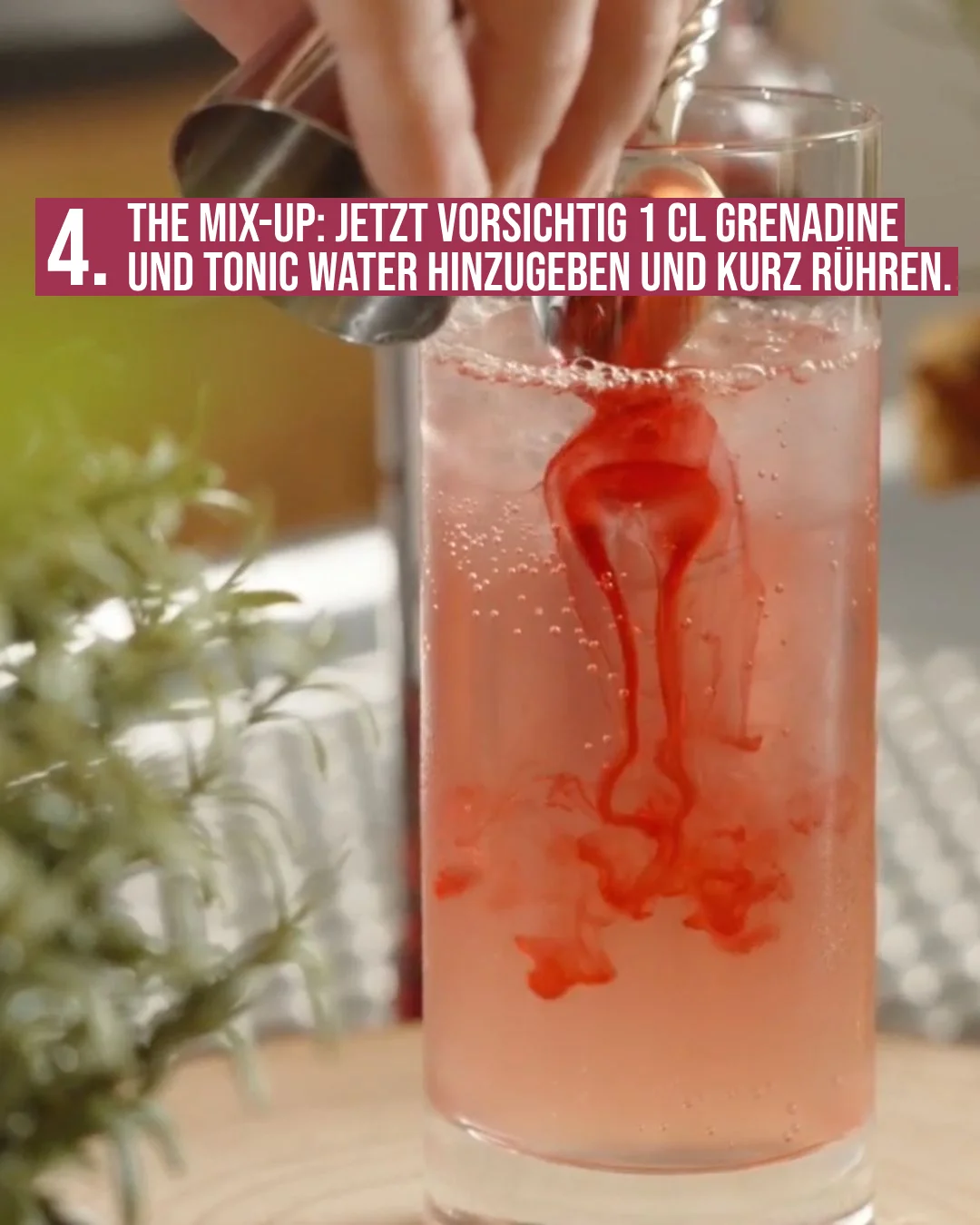 Cocktail-Rezept: Grenadine wird vorsichtig in ein Glas mit rosafarbenem Getränk gegossen und verrührt